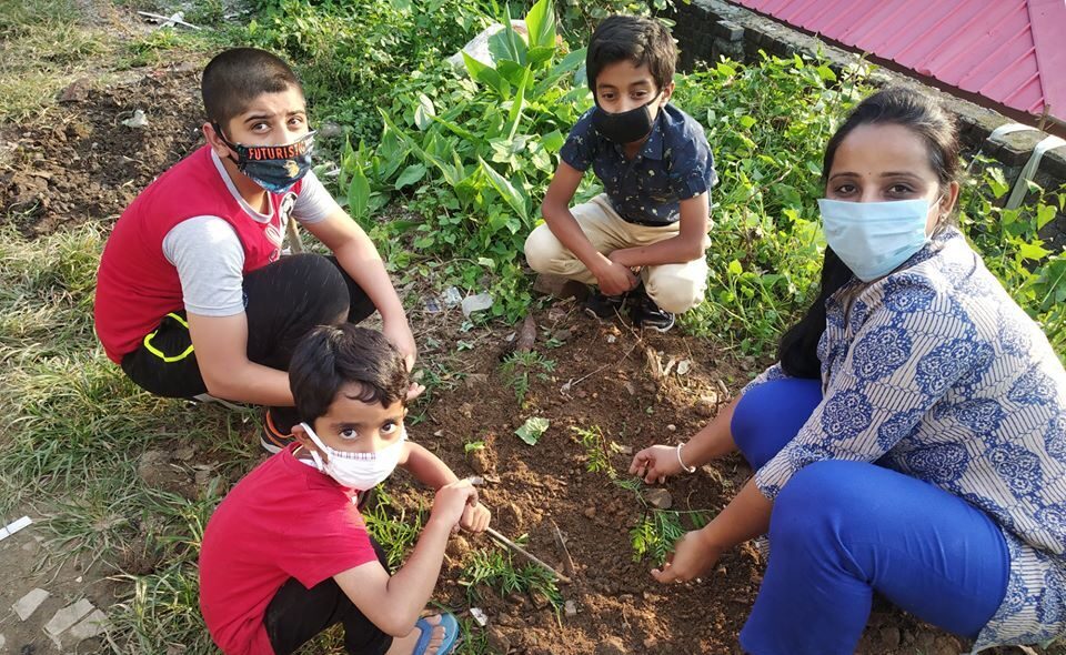 Community coordinator planting trees with children.